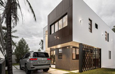 A white 3 bedroom storey house with wooden brown facad for sale in Regimanuel Satellite City Adenta Accra